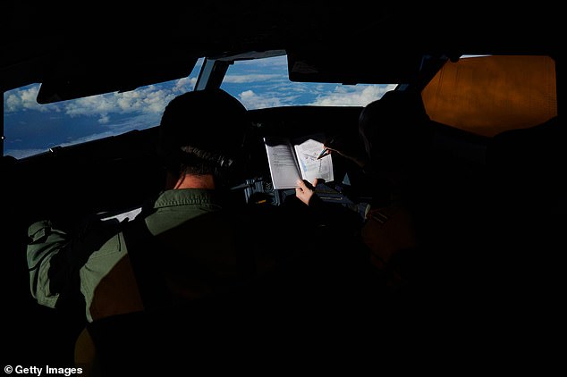Members of the flight crew check the mapping plan before a F-35B from the US Marine Corp and RAF Typhoon combat aircraft refuel from an RAF Voyager aircraft over the North Sea